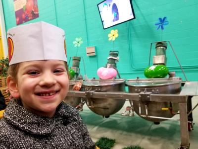 Girl at Jelly Belly in front of silver bean mixing pots