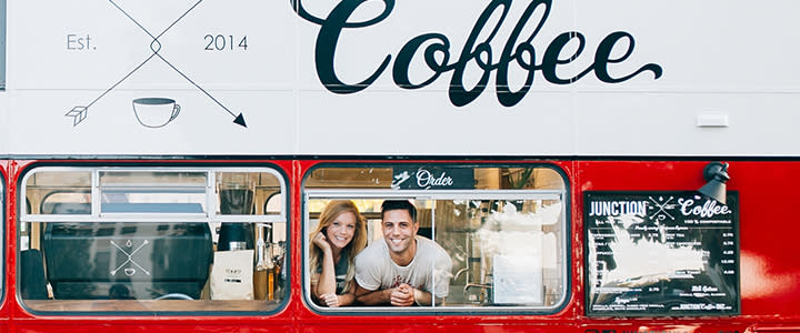 Owneres of Junction Coffee in the window of the double-decker bus