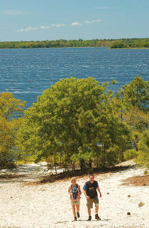 Friends walking up Sugar Loaf sand dune at Carolina Beach