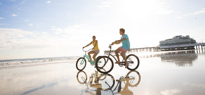 Ein Paar genießt das Radfahren am Daytona Beach in der Nähe des Main Street Pier