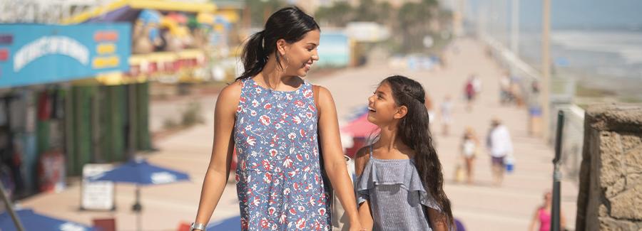 A mother and daughter enjoy strolling along the Daytona Beach Boardwalk