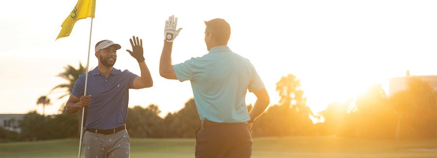 Golfers high five on the green at one of Daytona Beach's many great golf courses