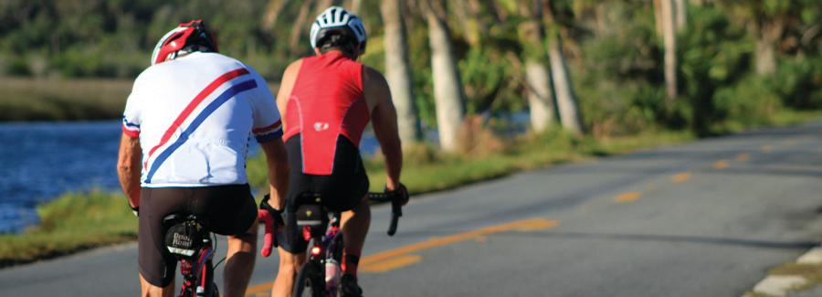 Two bicyclists ride through the Ormond Scenic Loop & Trail