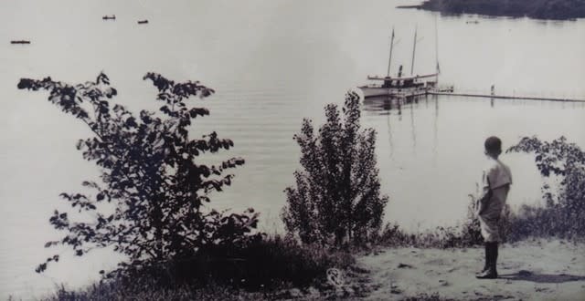 Historic photo of boy overlooking Saratoga Lake with boat in background