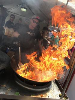 Wok bursting with flames at a food stall at the Columbus Arts Festival