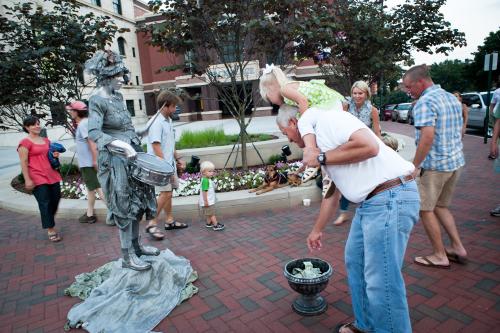 Man tipping Silver Lady statue street performer