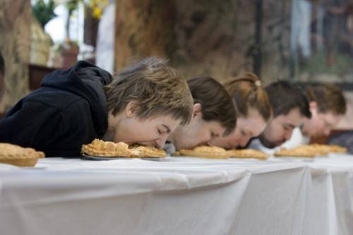 A row of people eating Apple Pie for Pi-Day