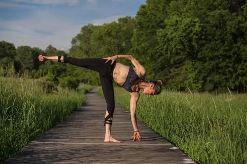 A woman doing yoga outside on a path