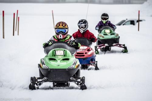 children ride snowmachines