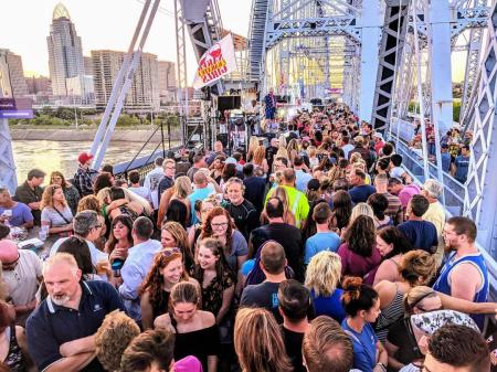 crowd of people and a band playing at party on the purple on the purple people bridge in newport ky and cincinnati oh