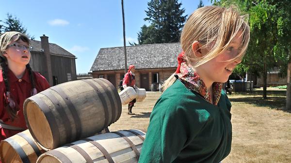 Two young girls at Fort Nisqually dress in period clothing for living history