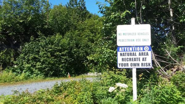 a safety advisory sign at a hiking trail head