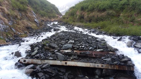 a ruined bridge over a gulch