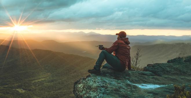 A hiker watching the sunset at McAfee Knob near Roanoke, Virginia