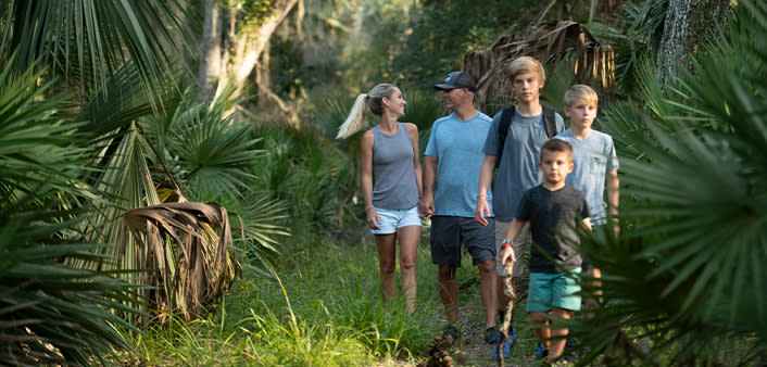 A family of five enjoys a hike.