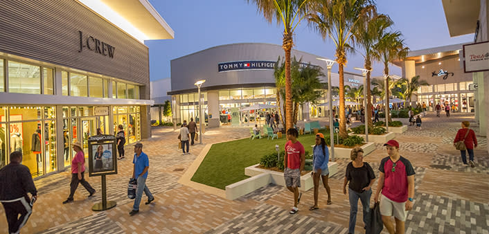 Shoppers stroll Tanger Outlet Daytona Beach at night