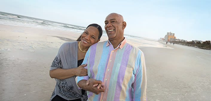 A couple enjoys a stroll on the beach