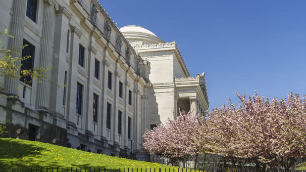 The outside of the Brooklyn Museum with cherry blossom trees at right