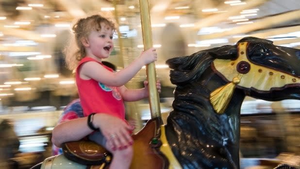 Child riding on the C. Fred Johnson Park Carousel