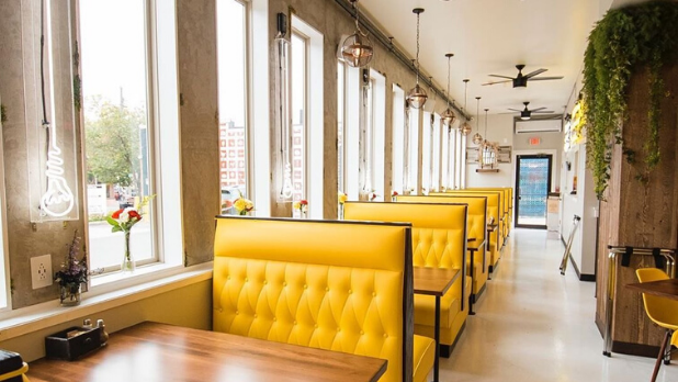 A photo of yellow restaurant booths inside of Rise N Shine Diner.