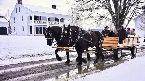 A family riding is a horse drawn carriage during the winter season