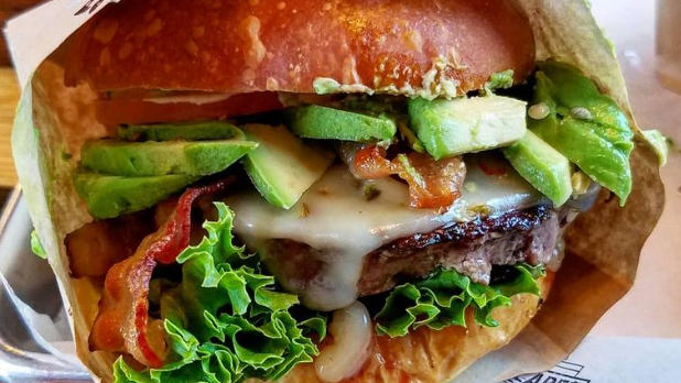 An Angus burger with lettuce, bacon and avocado