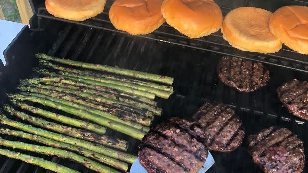 Asparagus, Butter Meat Co. burgers and buns on grill