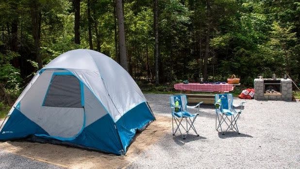 A tent, two chairs, and a picnic table at a campsite at Frontier Land