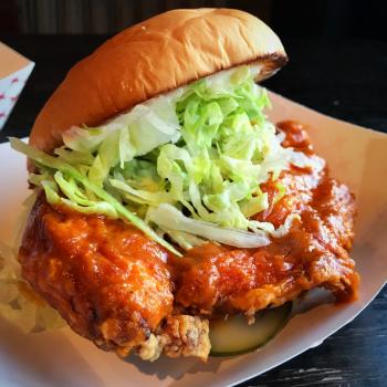 Hot Chicken Sandwich from Preston's Burgers topped with pickles, saucy chicken, and lettuce