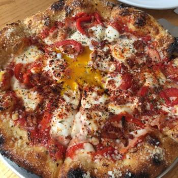 Pizza topped with cheese, tomatoes and egg yolk from Harvest in Bexley
