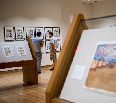 Close up of artwork with patrons in background at the Billy Ireland Cartoon Museum