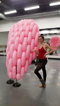 Rochester City Ballet Dancer stands next to a piece of the balloon set created by Airigami Studio