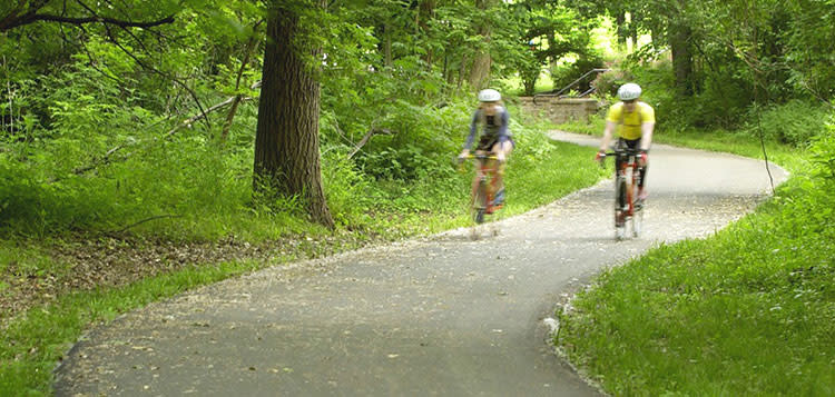 Two bicyclists on the Indian Creek Bike Trail in Overland Park