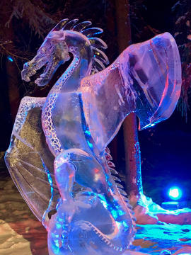 close up of a lighted large dragon carved from clear ice