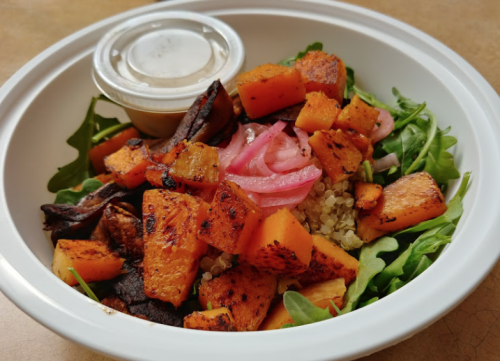 A Grain Bowl from Invoke is topped with quinoa, arugula, sweet potato & pickled radish.