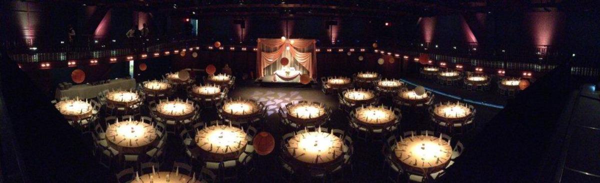 a dark room featuring tables and paper lanterns