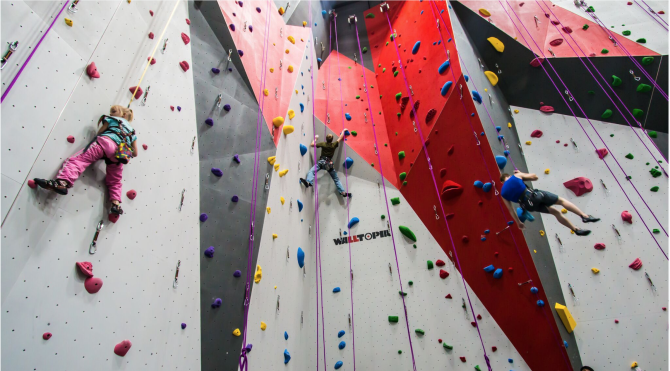 A family climbs the wall at Bliss Climbing and Fitness