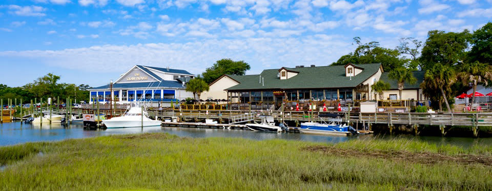 A view of the Murrells Inlet MarshWalk with boats docked at the Dead Dog Saloon