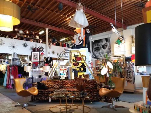 Retro furniture, mannequins, clothing and home decor on the floor of Flower Child Vintage store