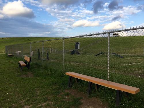 Bark Park Dog Park features fun equipment for dogs to play on and benches for their owners to sit while they watch.