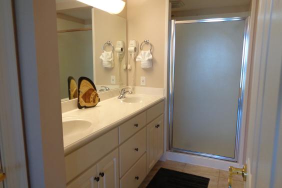 Master bath with marble vanities, dual shower heads, private commode, walk in closet