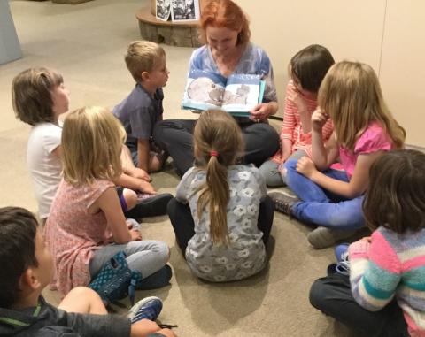 a woman reads a story to children