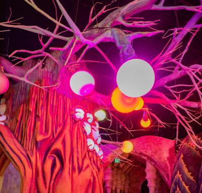 View of colorful artistic tree sculpture adorned with LED orbs inside Otherworld exhibit