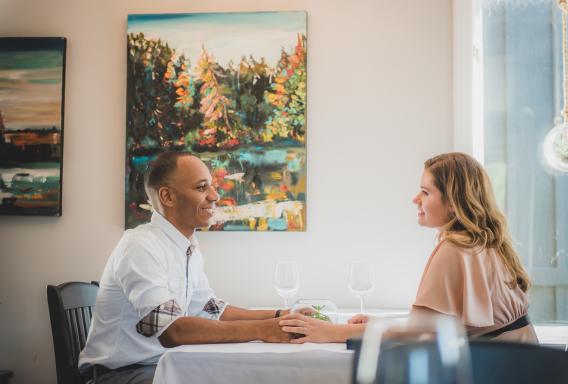 Couple holding hand at table