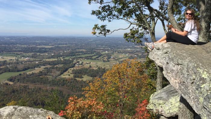 Woman sitting on rock along House Mountain trail overlooking Knoxville area