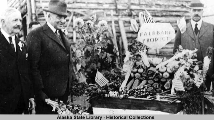 Gov. Bone, left, with President Harding as they inspect a display of vegetables grown in Fairbanks; unidentified man, right