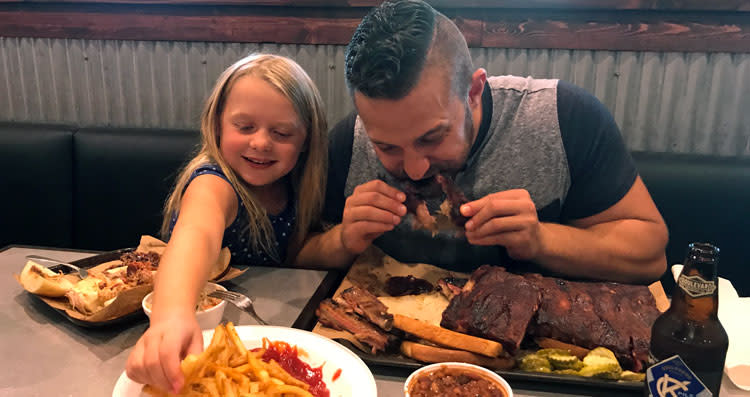 Father and daughter enjoy Joe's KC Ribs and BBQ