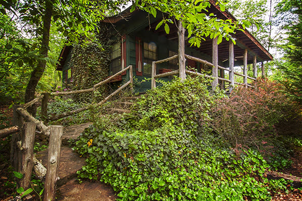 A cabin on a hill surround by trees.