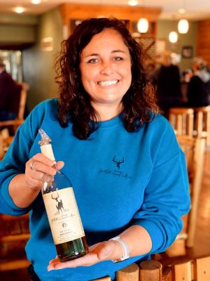 Christy Flyntz Holding a Bottle of White Tail Wine in Edgerton, KS