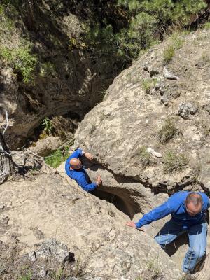 Two men climb up through a small, sandstone ravine near Albin, Wyoming.